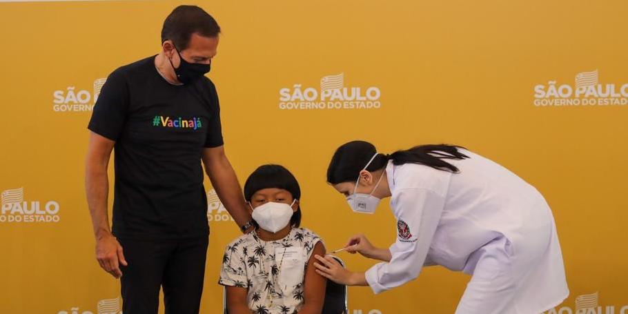 Governador João Doria (PSDB) posa para foto com a primeira criança vacinada (Divulgação/Governo de SP)